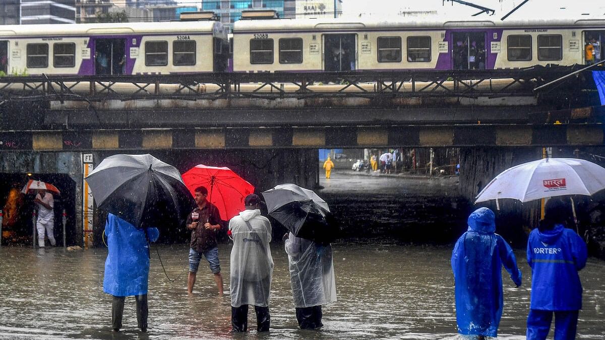 <div class="paragraphs"><p>A train passes above the Andheri subway which has been closed due to waterlogging during heavy rainfall, in Mumbai.</p></div>