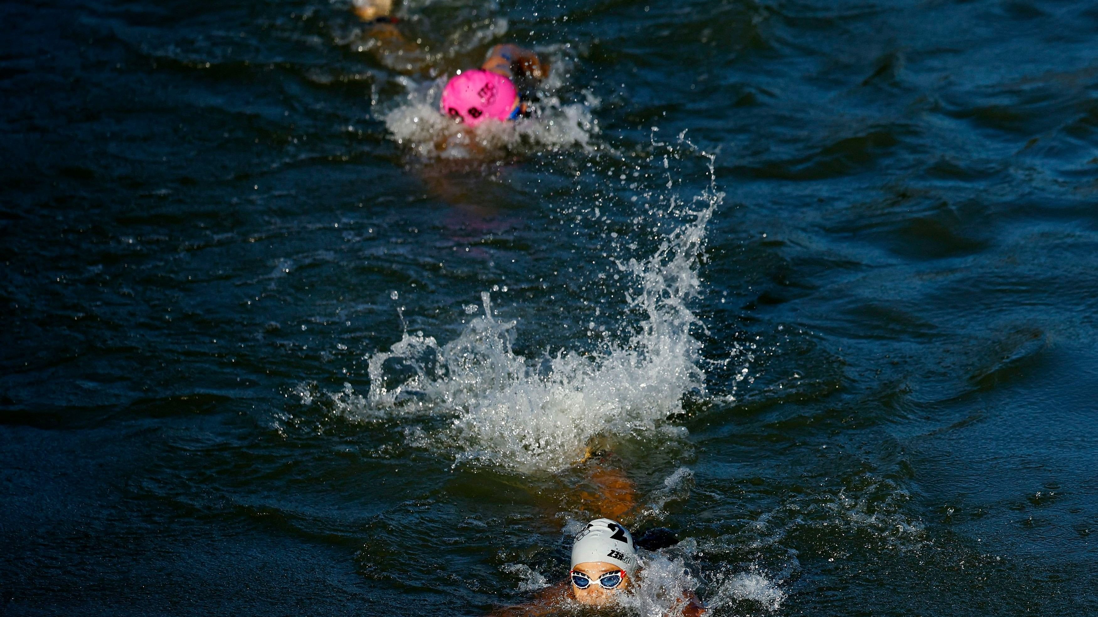 Paris 2024 Olympics - Triathlon - Mixed Relay - Paris, France - August 05, 2024. Athletes in action in the river Seine during the race. REUTERS/Albert Gea