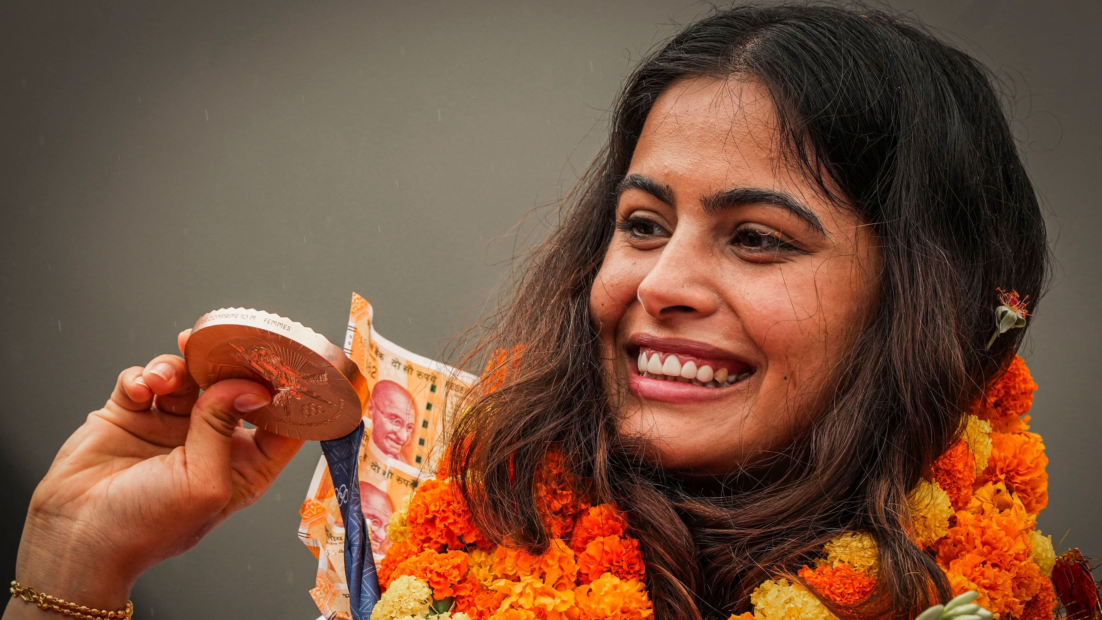 <div class="paragraphs"><p>Manu Bhaker being welcomed upon her arrival at the airport in New Delhi, Wednesday, August 7, 2024. Bhaker, India's first to win two Olympic medals in a single edition, arrived Delhi after a successful campaign at the Paris Games 2024. </p></div>