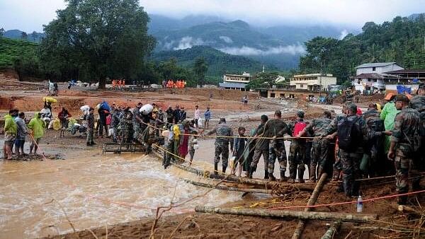 <div class="paragraphs"><p>Army soldiers help trapped people to cross a temporary bridge at a landslide site after multiple landslides in the hills in Wayanad district, in the southern state of Kerala.</p></div>