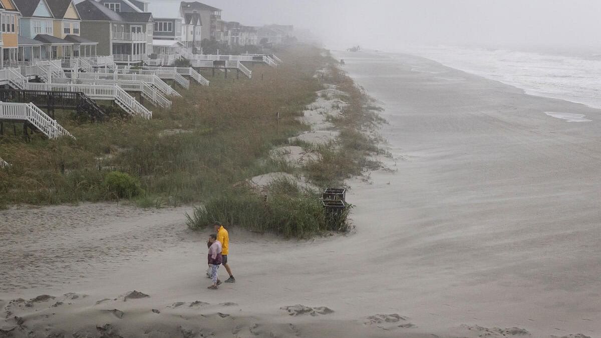 <div class="paragraphs"><p>People walk on the beach as Tropical Storm Debby drifts in the East Coast, in Surfside Beach, South Carolina.</p></div>