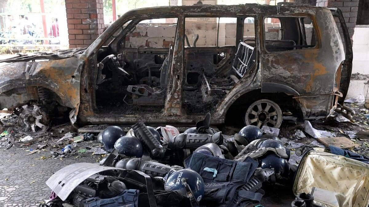 <div class="paragraphs"><p>Damaged riot gear of security forces is seen next to a burnt vehicle outside a police station, days after the resignation of former Bangladeshi Prime Minister Sheikh Hasina, in Dhaka.</p></div>