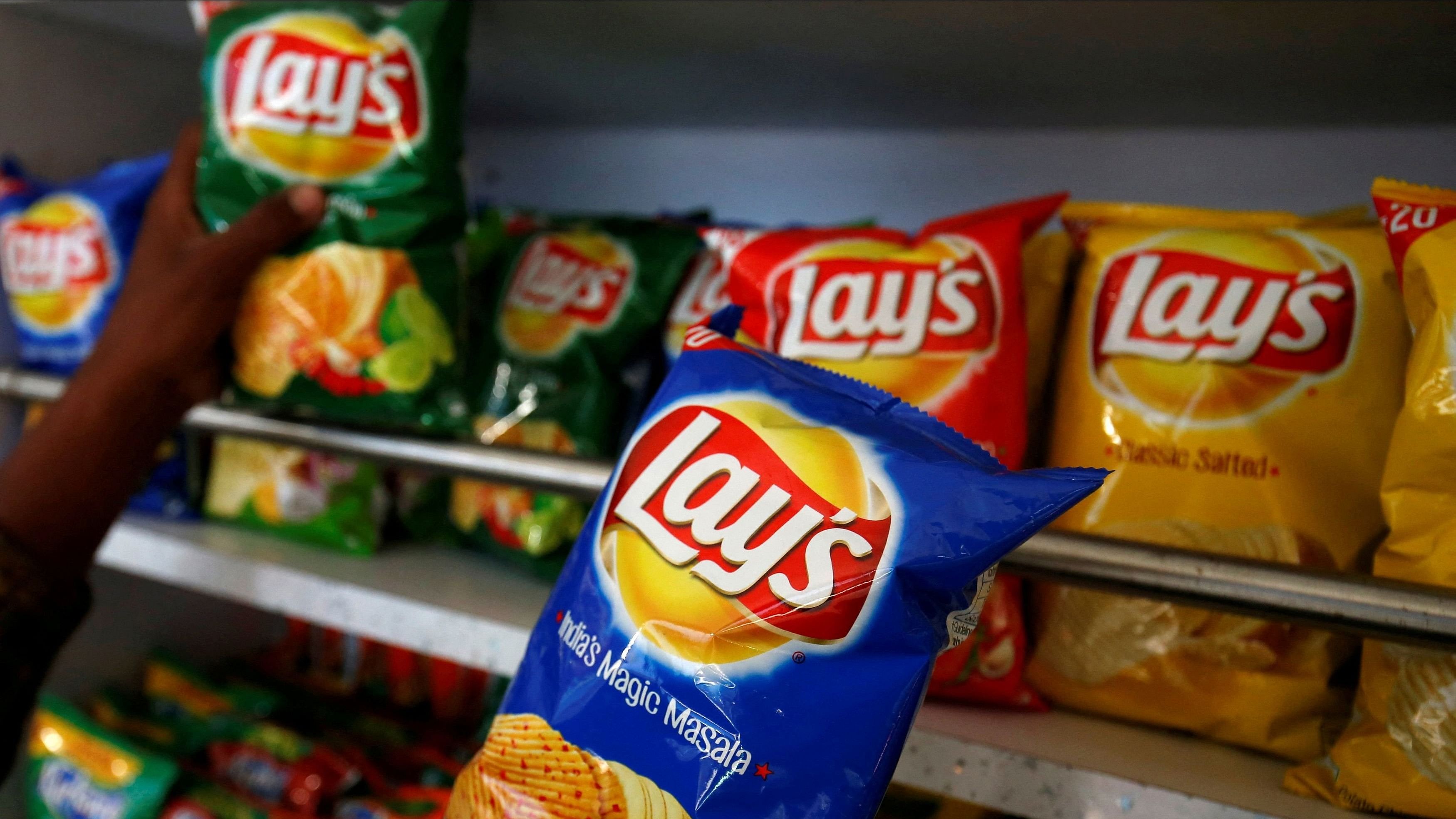 <div class="paragraphs"><p> A customer picks packets of PepsiCo Lay's potato chips at a shop in Ahmedabad </p></div>