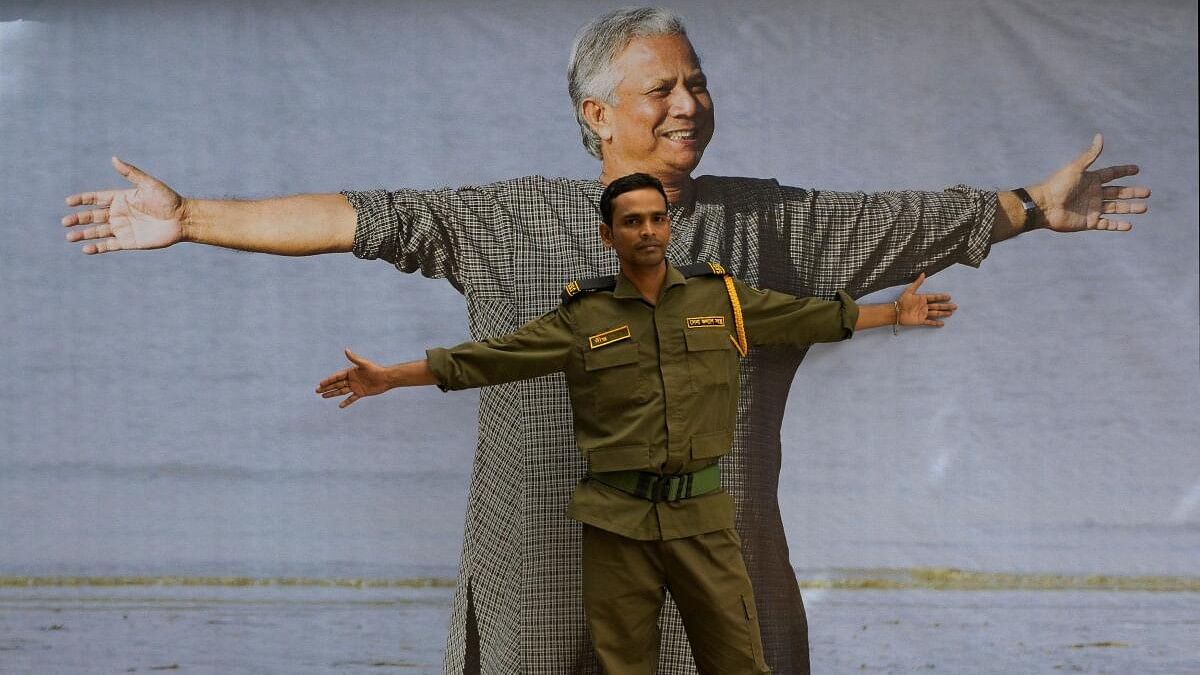 <div class="paragraphs"><p>A security guard of a bank poses with a photograph of Nobel Peace Prize laureate Muhammad Yunus in Dhaka, Bangladesh, August 8, 2024.</p></div>