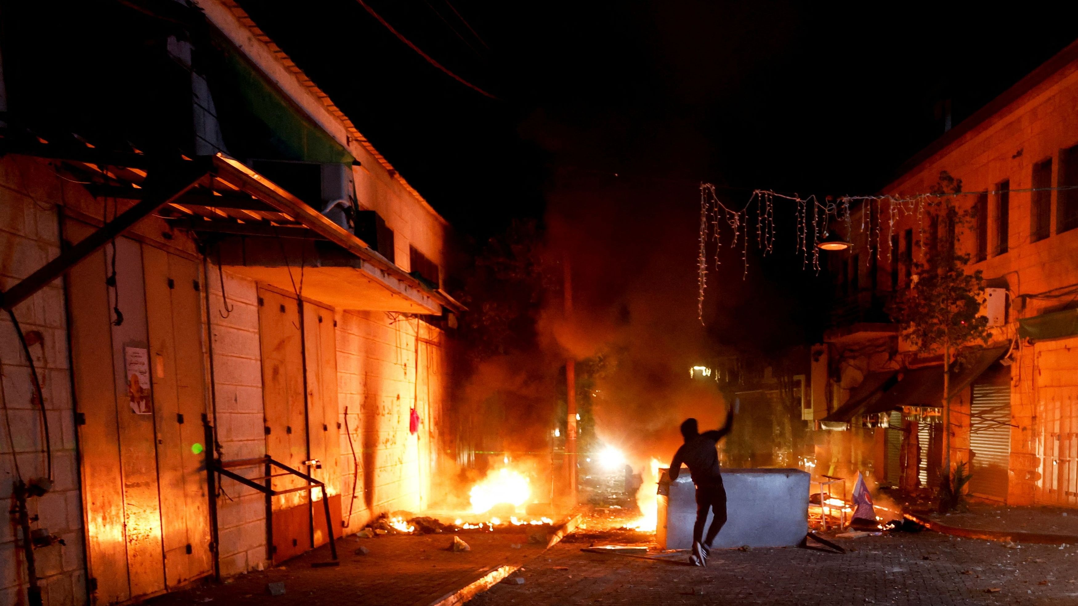 <div class="paragraphs"><p>A Palestinian throws stones amid Israeli army raids on the West Bank.</p></div>