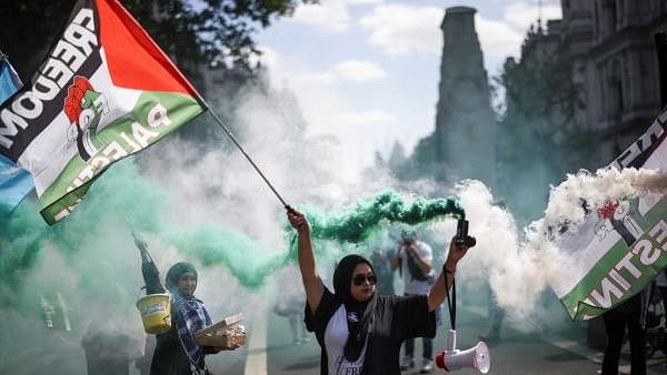 <div class="paragraphs"><p>A protester carries a smoke flare during a pro-Palestine demonstration.&nbsp;</p></div>