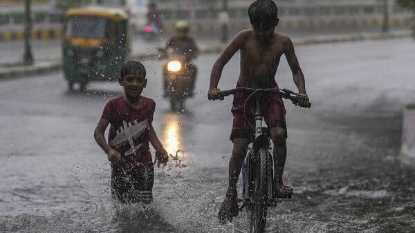 <div class="paragraphs"><p>Children at a waterlogged road during rain, in New Delhi, Sunday, August 11, 2024. </p></div>