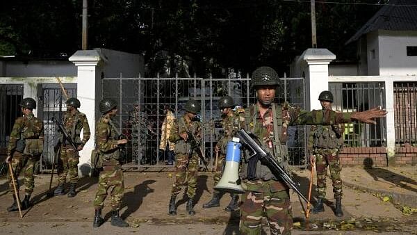 <div class="paragraphs"><p>Security personnel stand guard next to a police station in Dhaka, Bangladesh.</p></div>