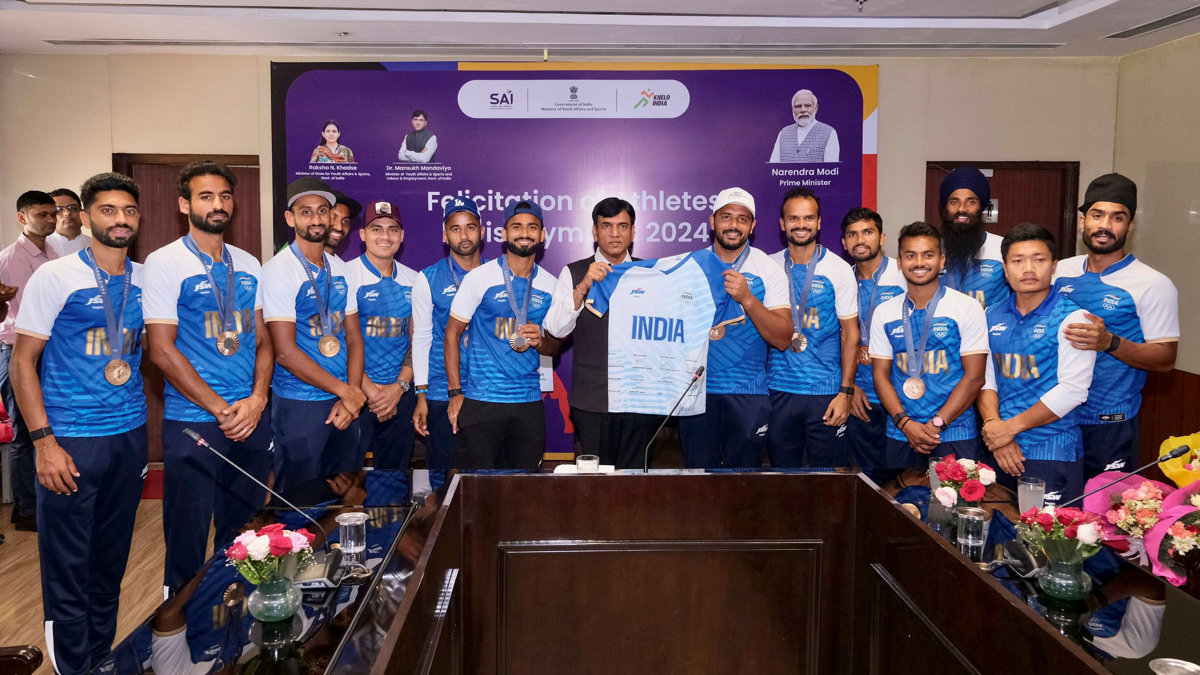 <div class="paragraphs"><p>Union Sports Minister Mansukh Mandaviya poses for a group photo during a meeting with Paris Olympic Bronze medalist Indian Hockey players, at Major Dhyan Chand National Stadium, in New Delhi, Saturday, Aug. 10, 2024.</p></div>