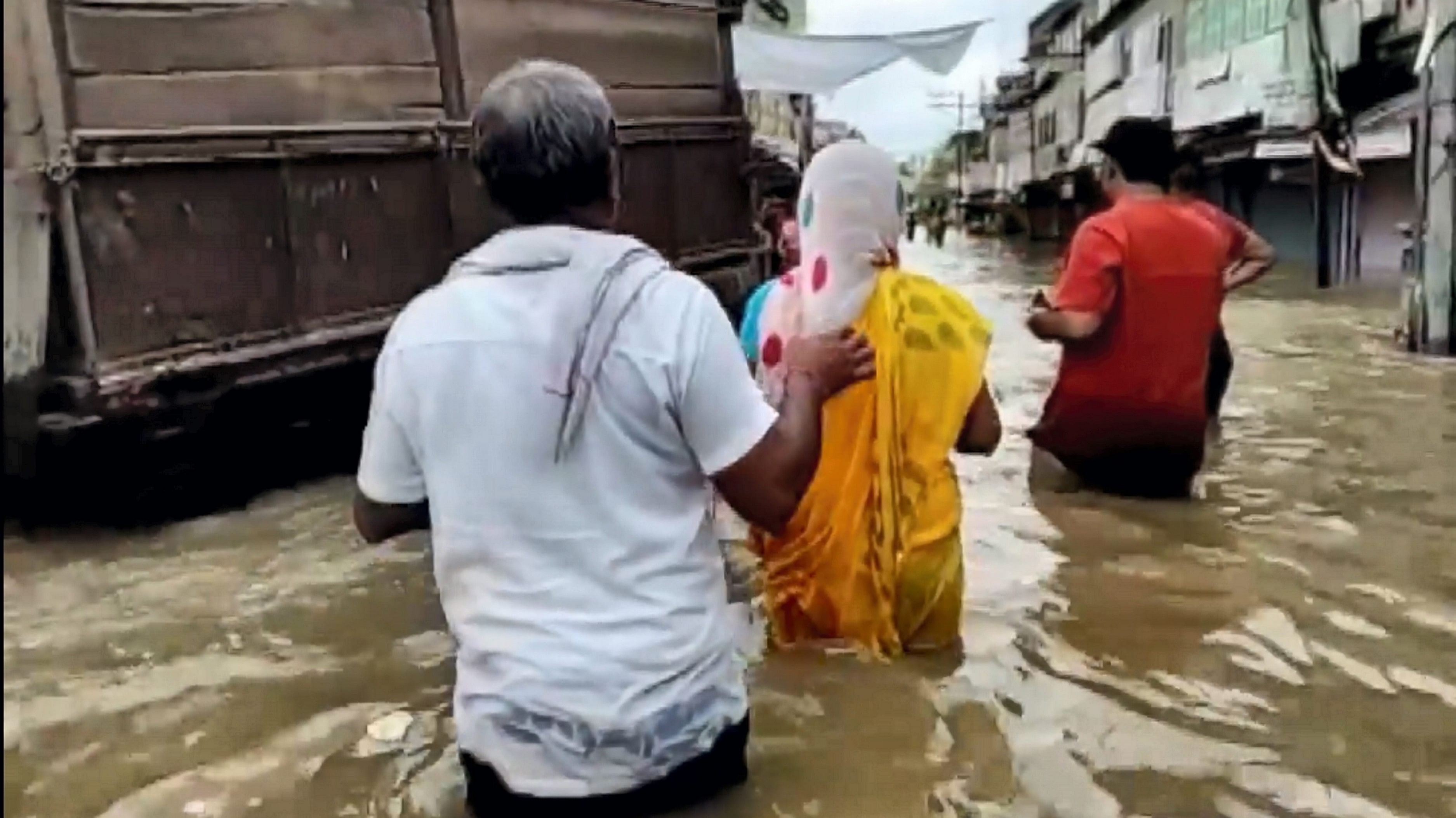 <div class="paragraphs"><p>People pass through a waterlogged area after heavy rainfall, in Hindaun city, Rajasthan, Sunday, Aug. 11, 2024.</p></div>