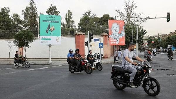 <div class="paragraphs"><p>People drive past a banner with a picture of late Hamas leader Ismail Haniyeh in a street in Tehran, Iran, August 12, 2024. </p></div>