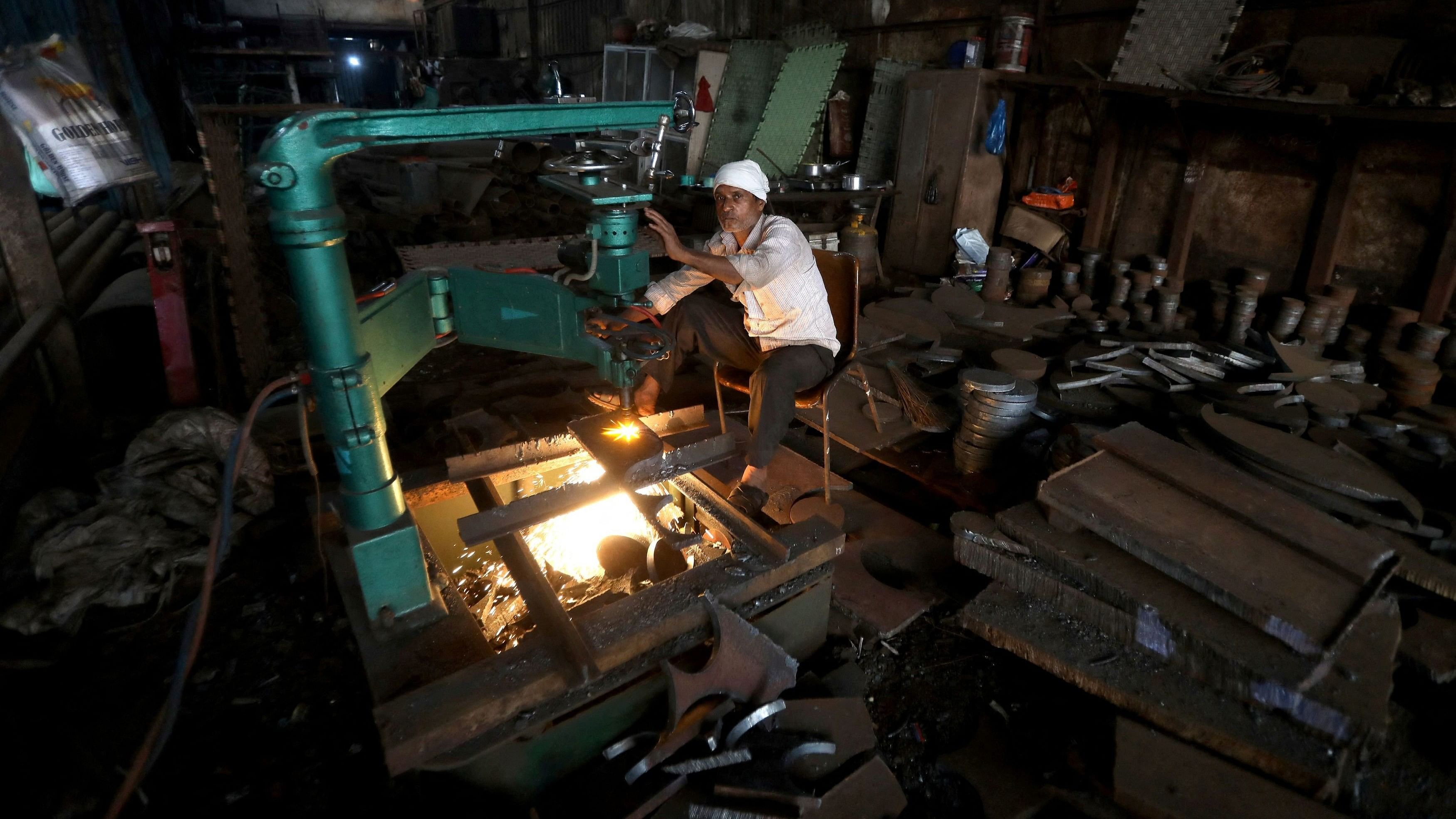 <div class="paragraphs"><p> A worker operates a machine inside a small scale manufacturing unit in Mumbai, India, February 1, 2023.</p></div>