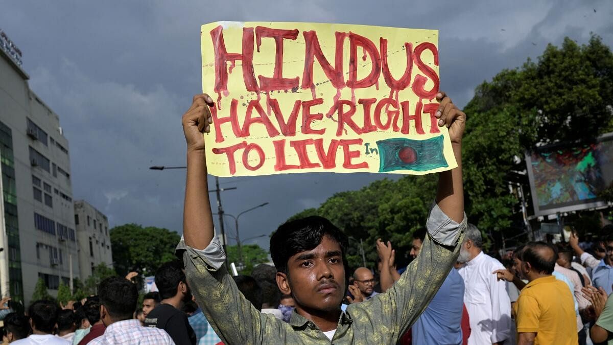 <div class="paragraphs"><p>A demonstrator displays a placard during a protest against alleged attacks against Hindu communities in Dhaka.</p></div>