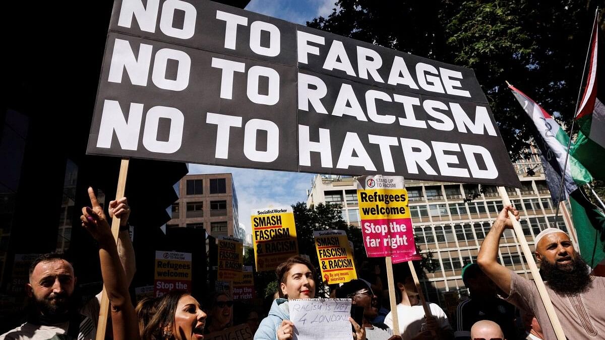 <div class="paragraphs"><p>People hold signs at a protest against racism outside Reform UK's headquarters in Westminster, in London.</p></div>