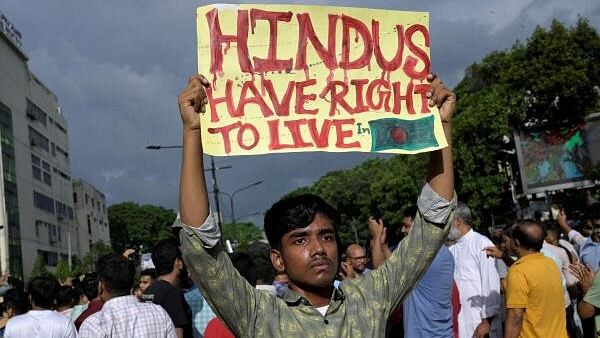 <div class="paragraphs"><p>A demonstrator displays a placard during a protest against what they say is violence against Hindu communities during ongoing unrest in Dhaka, Bangladesh, August 9, 2024. </p></div>