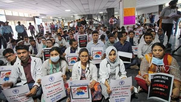 <div class="paragraphs"><p>Members of Resident Doctors Association (RDA) of AIIMS hold placards during a protest to show solidarity with their counterparts in West Bengal, in New Delhi.</p></div>