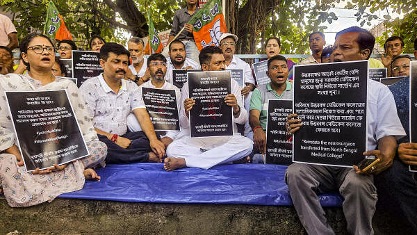 <div class="paragraphs"><p>BJP leader Shankar Ghosh (centre) with other party supporters holds a placard during a protest against the West Bengal TMC government over the alleged rape and murder of a woman doctor at Kolkata's R G Kar Medical College and Hospital, in Siliguri, Friday, Aug. 16, 2024. </p></div>