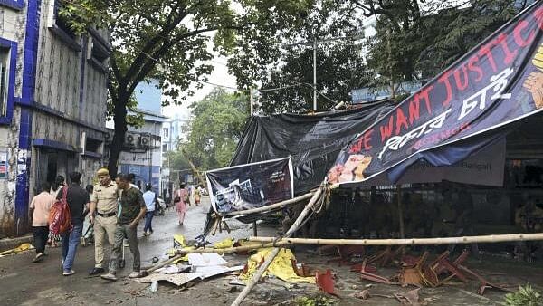 <div class="paragraphs"><p> A police personnel near a vandalised protest site outside RG Kar Medical College and Hospital amid demonstrations against the alleged rape and murder of a post graduate trainee doctor, in Kolkata.</p></div>