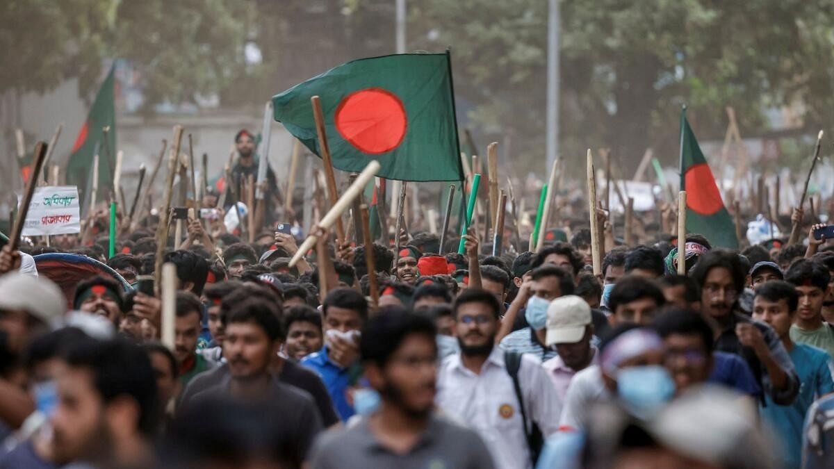 <div class="paragraphs"><p>Anti-quota protesters march with Bangladeshi flags and sticks as they engage in a clash with Bangladesh Chhatra League, the student wing of the ruling party Bangladesh Awami League, at the University of Dhaka, in Dhaka.</p></div>