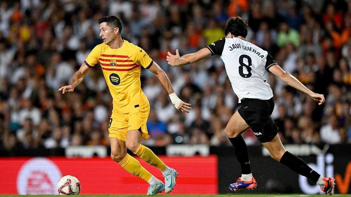 <div class="paragraphs"><p>FC Barcelona's Robert Lewandowski in action with Valencia's Javi Guerra.</p></div>