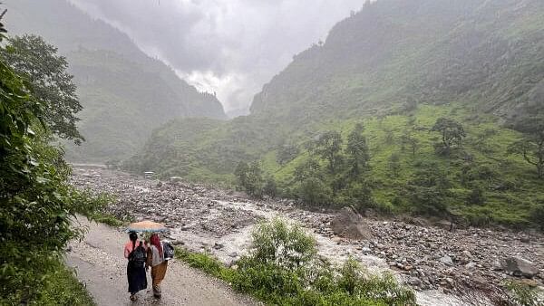 <div class="paragraphs"><p>Women walk on a road amid rains at cloud-burst hit Samej village, in Rampur area of Shimla district, Friday, Aug. 2, 2024.</p></div>