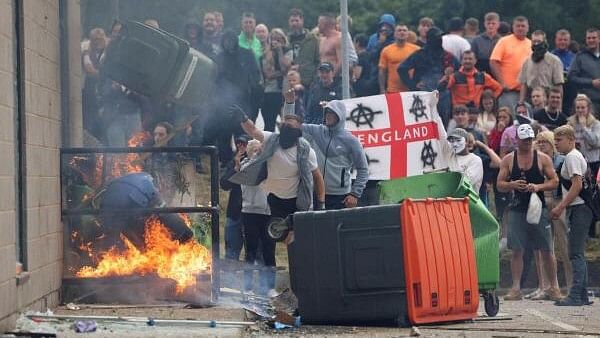 <div class="paragraphs"><p>Demonstrators toss a trash bin during an anti-immigration protest, in Rotherham, Britain.&nbsp;</p></div>