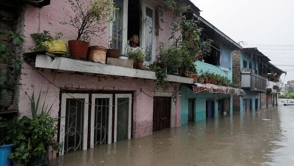 <div class="paragraphs"><p>File photo of a man looking out from the window of his house in an area flooded by the overflowing Bagmati river following heavy rains, in Kathmandu, Nepal.</p></div>