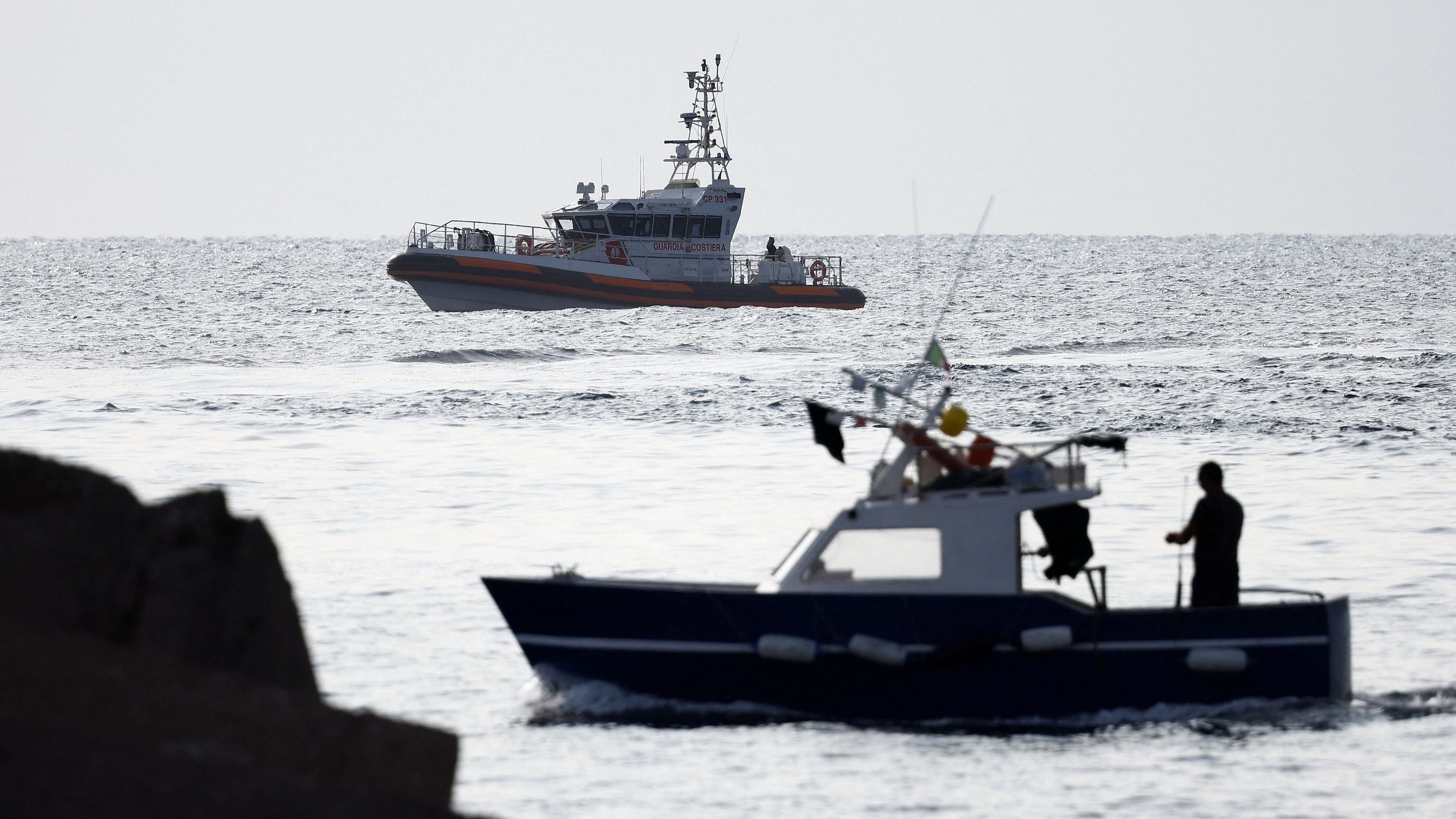 <div class="paragraphs"><p>A fishing boat sails past a coast guard vessel operating in the sea to search for the missing, including British entrepreneur Mike Lynch, after a luxury yacht sank off the coast of Porticello, near the Sicilian city of Palermo, Italy.</p></div>