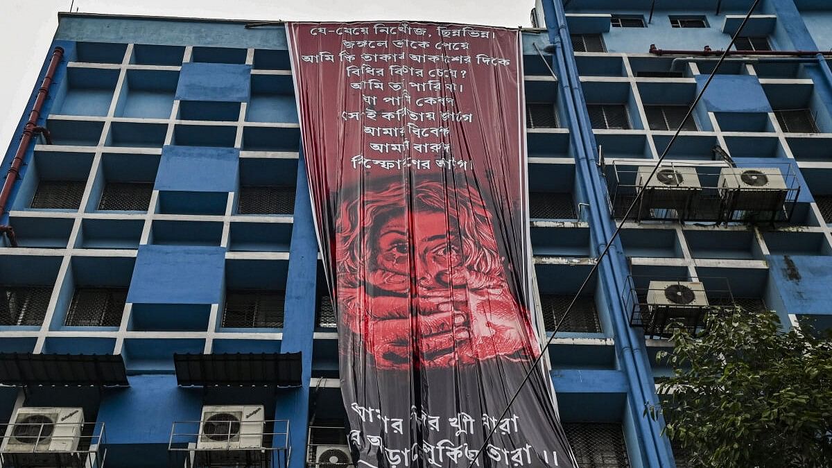 <div class="paragraphs"><p>Junior doctors hang a giant poster from the roof of the R G Kar College and Hospital during their protest against alleged rape and murder of a woman trainee doctor of the hospital, in Kolkata, Tuesday, Aug. 20, 2024.</p></div>