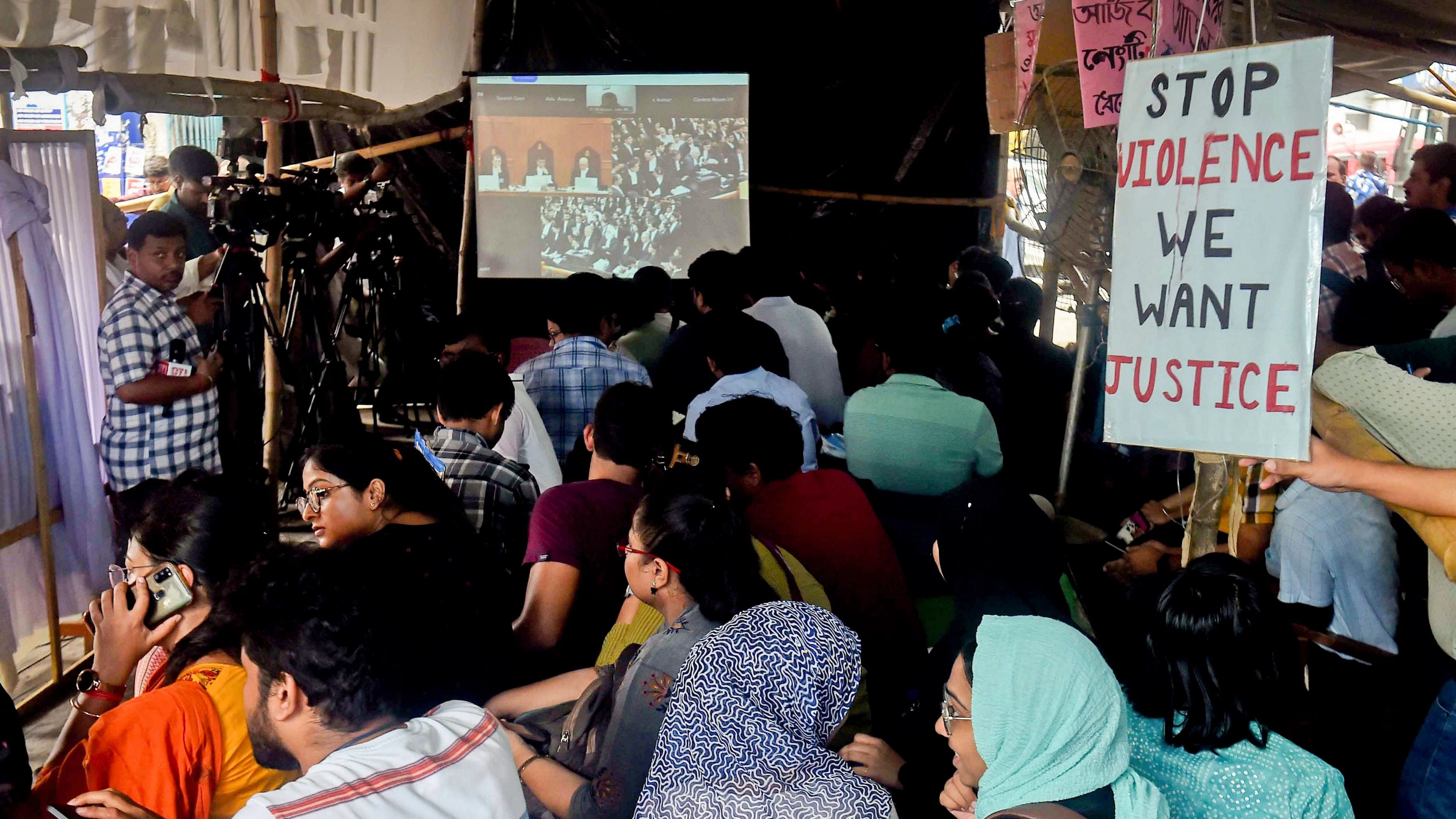 <div class="paragraphs"><p>Kolkata: Resident doctors of RG Kar Medical College and Hospital watch live streaming of the Supreme Court hearing in the alleged rape and murder of a trainee woman doctor inside the hospital during their protest, in Kolkata, Thursday, Aug. 22, 2024.</p></div>