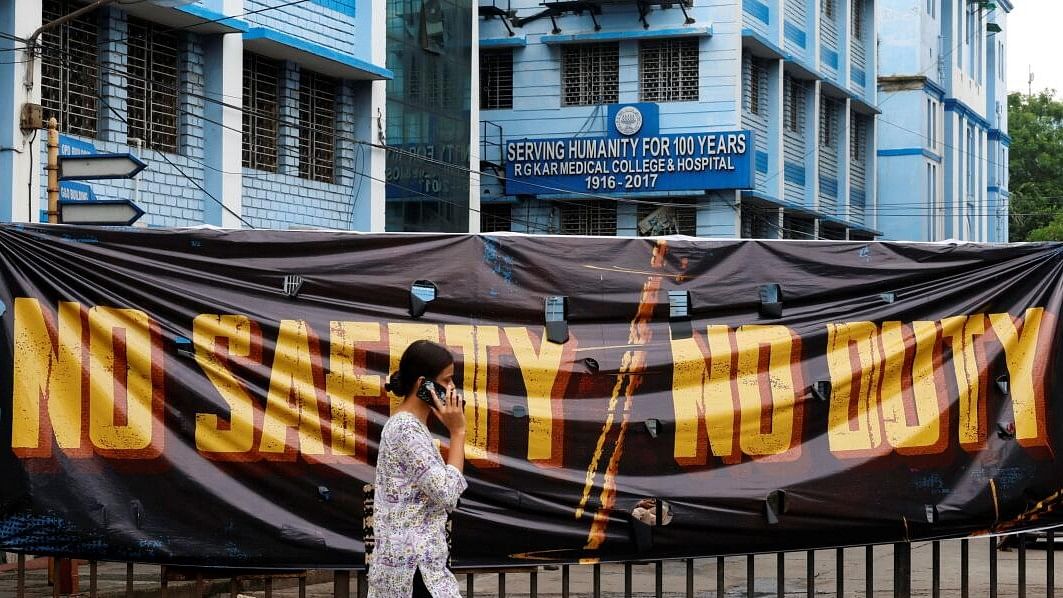 <div class="paragraphs"><p>A woman walks past a closed gate of R G Kar Medical College and Hospital in Kolkata.</p></div>