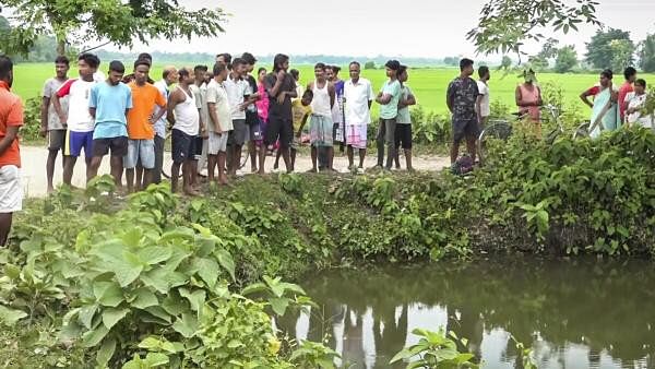 <div class="paragraphs"><p>People gather near the pond where prime accused in the alleged rape of a minor girl jumped and died, at Dhing, in Nagaon district, Saturday.&nbsp;</p></div>