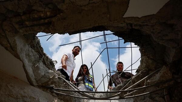 <div class="paragraphs"><p>People look at the damage at a residential building following a direct-hit from a projectile, after Hezbollah launched hundreds of rockets and drones towards Israel in what the Iranian-backed movement said was a response to the assassination of a senior commander in Beirut last month, in northern Israel August 25</p></div>