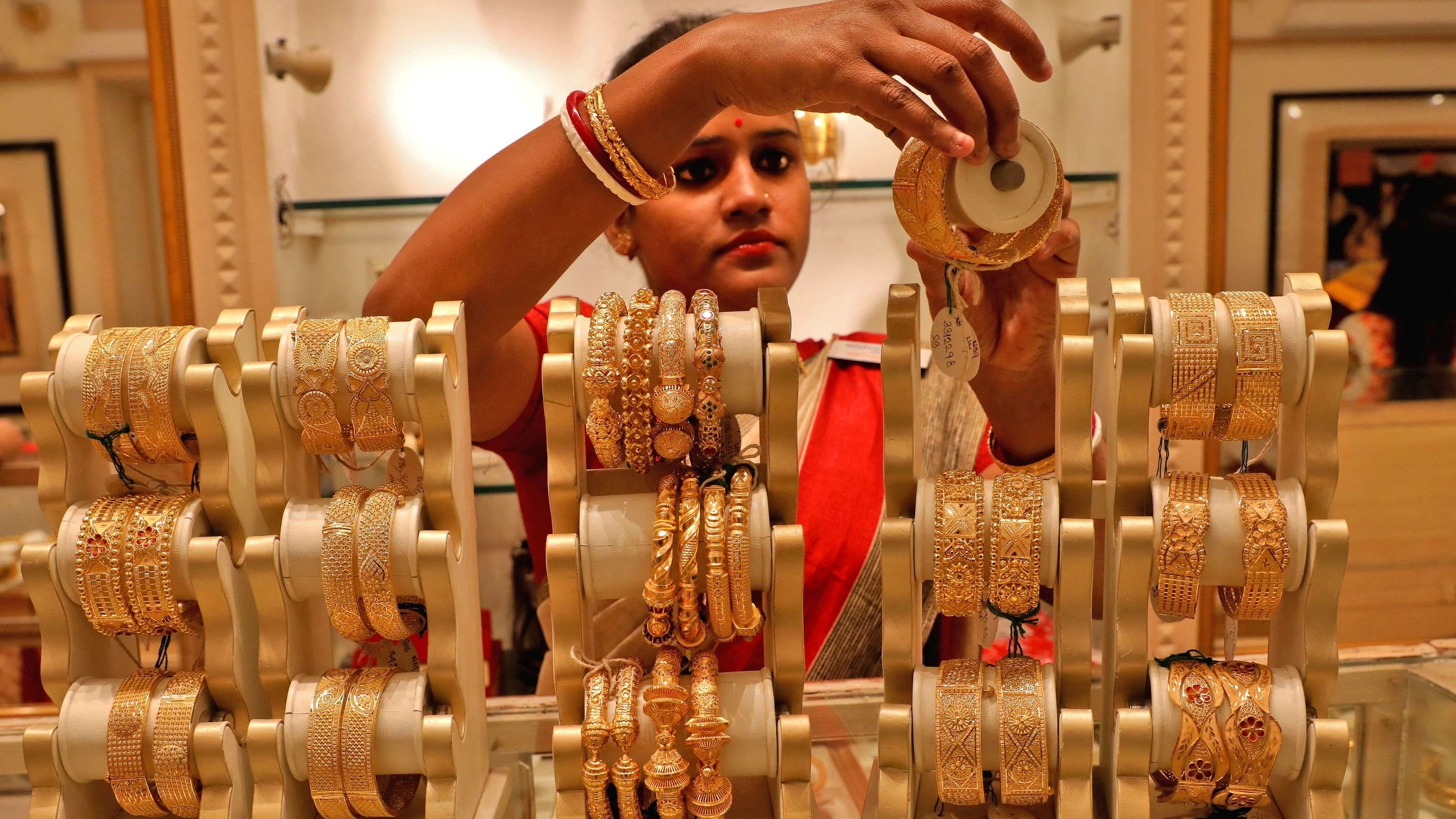 <div class="paragraphs"><p>A saleswoman shows gold bangles to a customer at a jewellery showroom on the occasion of Akshaya Tritiya, a major gold buying festival.&nbsp;</p></div>