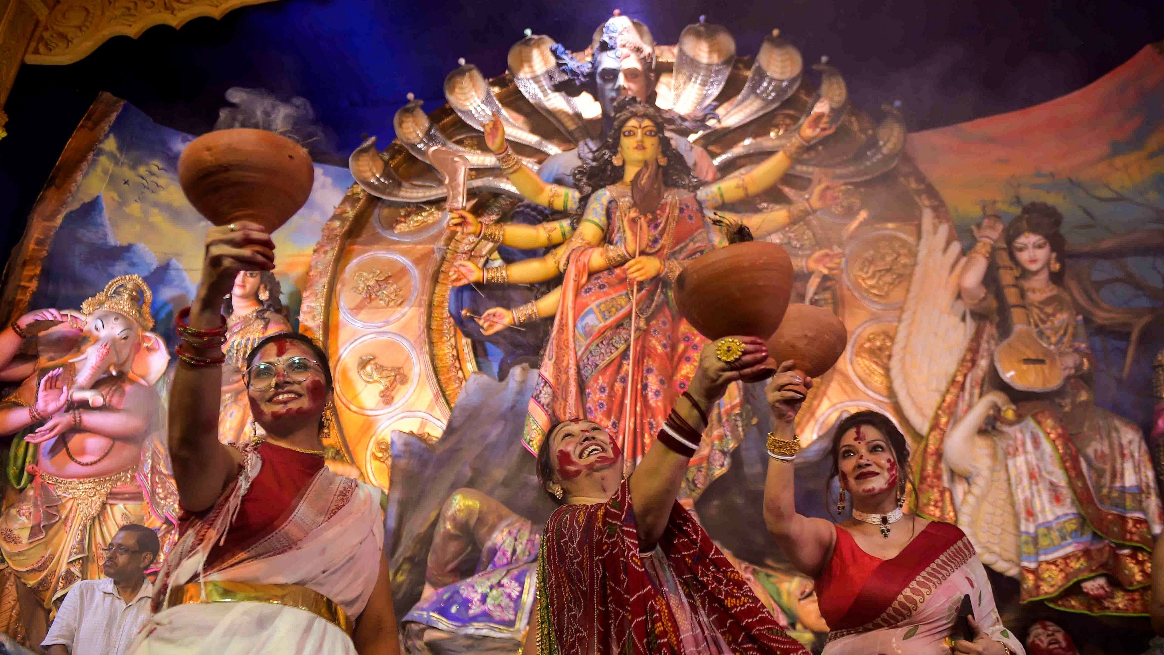 <div class="paragraphs"><p>Devotees perform 'Dhunuchi' dance at a community 'puja pandal' during Durga Puja </p></div>