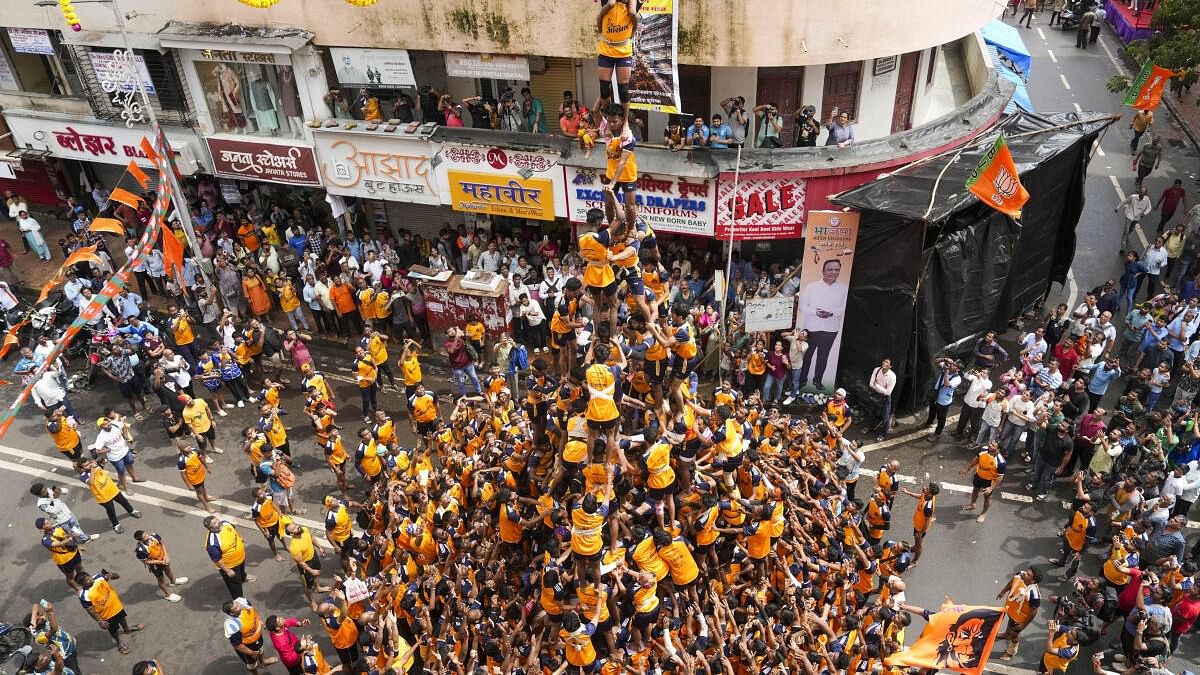 <div class="paragraphs"><p>Devotees form a human pyramid to break the 'dahi handi', an earthen pot filled with curd, as part of 'Janmashtami' festival celebrations, at Dadar in Mumbai</p></div>