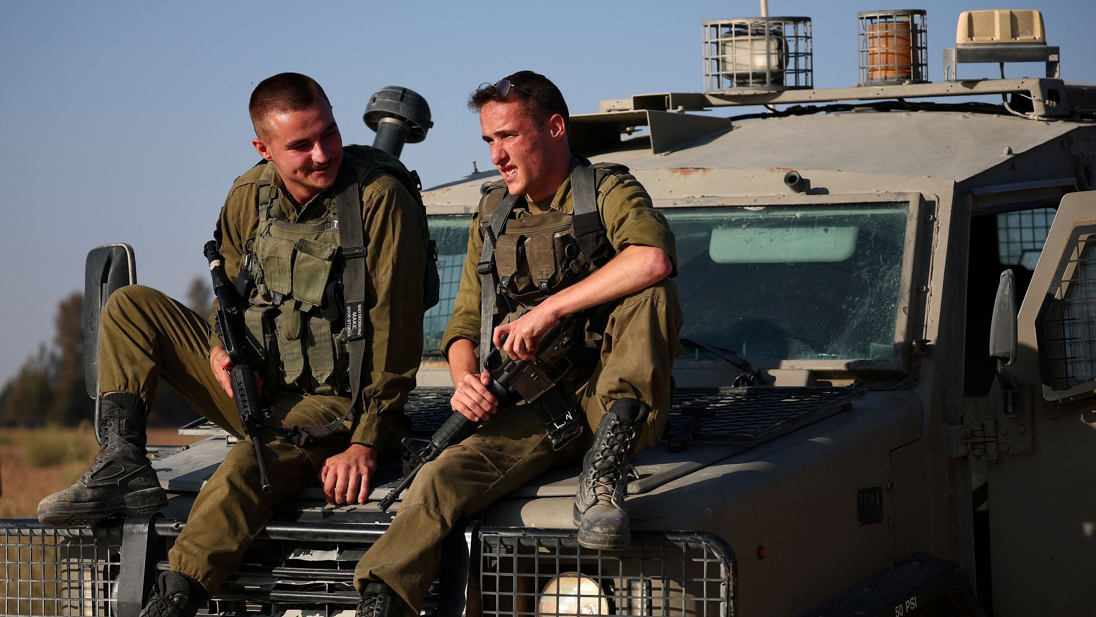 <div class="paragraphs"><p>Israeli soldiers sit on a military vehicle near the Israel-Gaza border, amid the Israel-Hamas conflict, in Israel.</p></div>