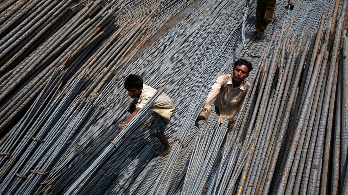 <div class="paragraphs"><p>Labourers load steel rods onto a truck at a steel factory.</p></div>