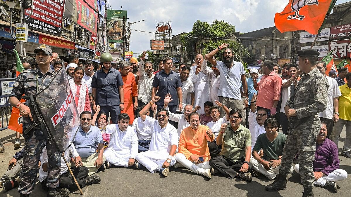 <div class="paragraphs"><p>BJP leader Rahul Sinha (sitting, 3rd from left) along with party workers raises slogans as security personnel stand guard during the party's 12-hour general strike in Bengal to protest the police action against participants of Tuesday's ‘Nabanna Abhijan’ rally, which was held against the RG Kar incident, in Kolkata.</p></div>