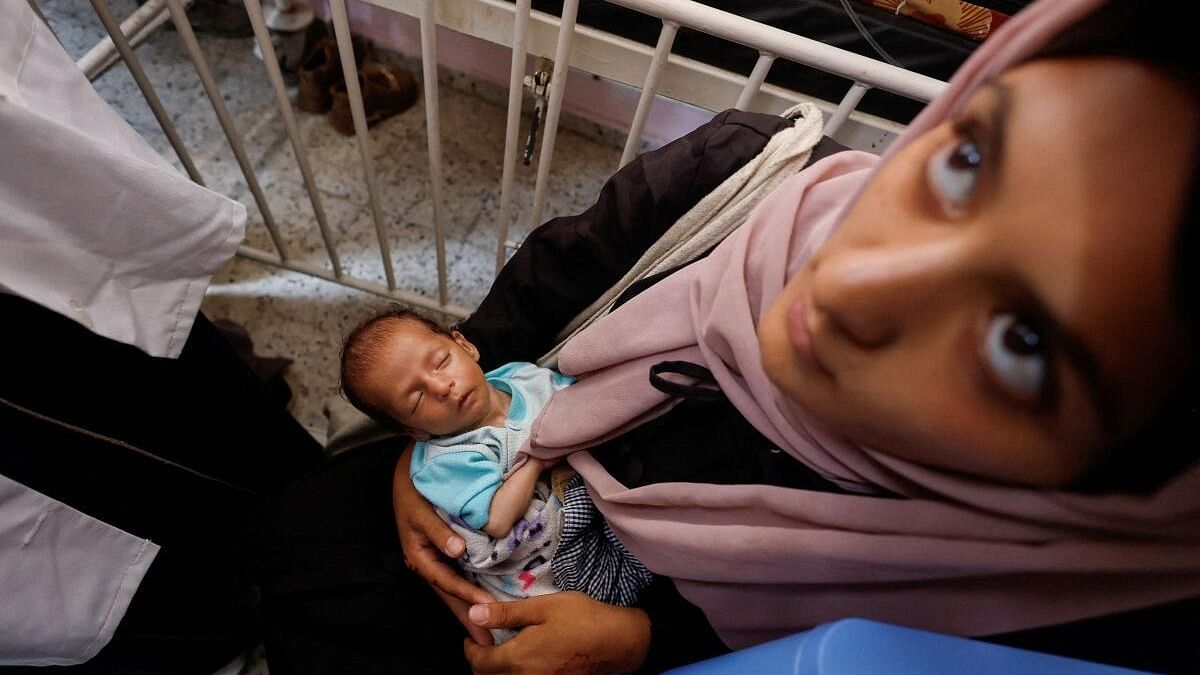 <div class="paragraphs"><p>A Palestinian woman holds a child, as children receive vaccinations against polio, amid the Israel-Hamas conflict, at Nasser hospital in Khan Younis in the southern Gaza Strip, August 31, 2024.</p></div>