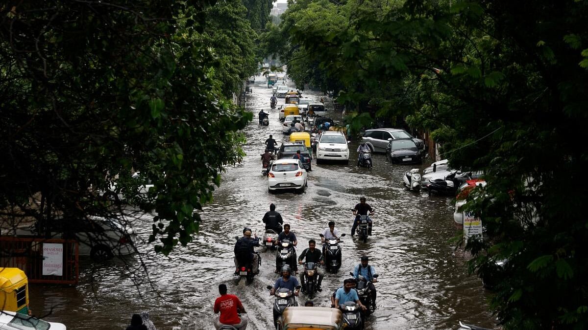 <div class="paragraphs"><p>Traffic moves through a flooded road after heavy rains in Ahmedabad, Gujarat.&nbsp;</p></div>