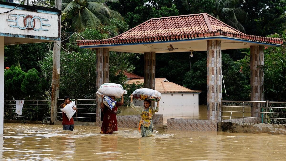 <div class="paragraphs"><p>People carrying sacks, wade through flood water, amid severe flooding in the Fazilpur area of Feni, Bangladesh.</p></div>