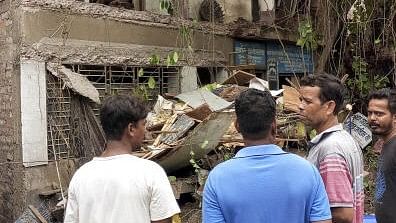 <div class="paragraphs"><p>People gather near the site of a building due that partially collapsed due to rain, at Baguihati area, in Kolkata, Friday.&nbsp;</p></div>