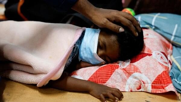 <div class="paragraphs"><p>Man pats his son's head, after he caught a high fever inside a relief camp, following landslides that hit several villages in Wayanad district, in Meppadi.</p></div>