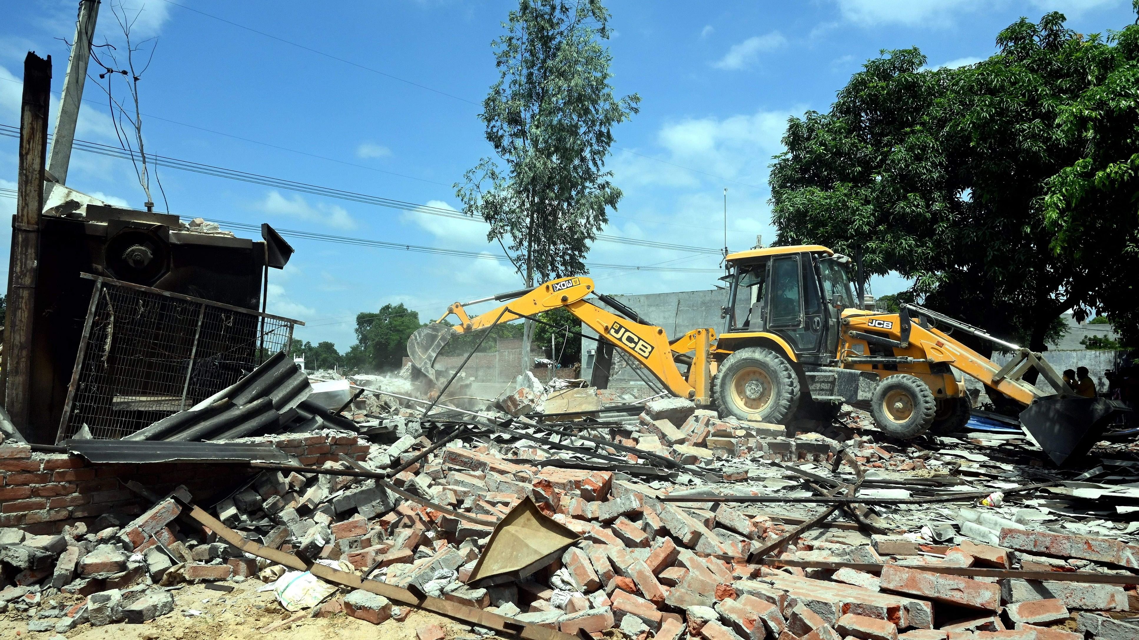 <div class="paragraphs"><p> A bulldozer being used to demolish the bakery of Moid Khan who is accused of allegedly raping a 12-year-old girl, in Ayodhya, Saturday.</p></div>