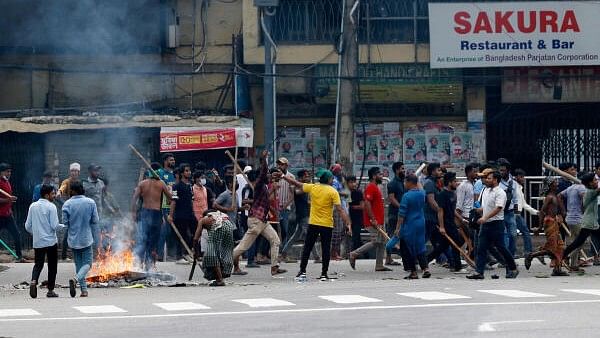 <div class="paragraphs"><p>Objects set on fire burn as demonstartors with sticks occupy the street during a protest demanding the stepping down of Bangladeshi Prime Minister Sheikh Hasina, following quota reform protests by students, in Dhaka, Bangladesh, August 4, 2024.</p></div>