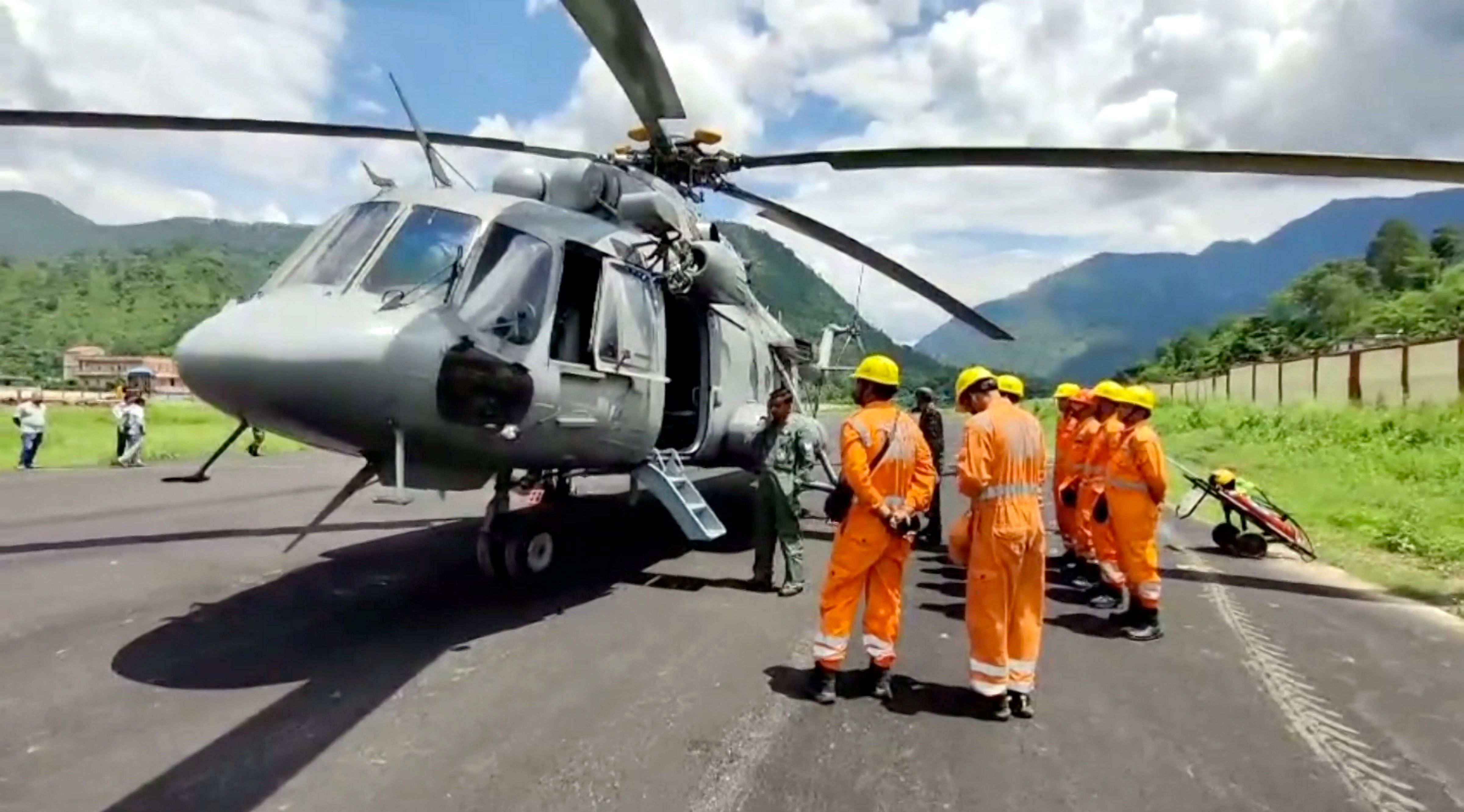 <div class="paragraphs"><p>NDRF personnel near a helicopter which is to be used for rescuing stranded people on the Kedarnath trek route after landslides triggered by cloudburst, at Gaucher, in Chamoli district</p></div>