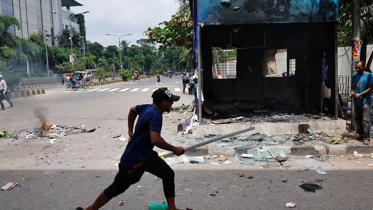 <div class="paragraphs"><p>A demonstrator runs next to a vandalised police box during a protest demanding the stepping down of Bangladeshi Prime Minister Sheikh Hasina, following quota reform protests by students, in Dhaka, Bangladesh.</p></div>