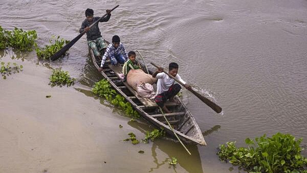 <div class="paragraphs"><p>Locals cross a flooded area on a boat, in Balimuk village of Morigaon district.&nbsp;</p></div>