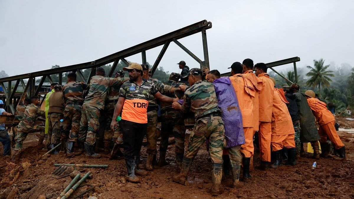 <div class="paragraphs"><p>Army personnel and volunteers lift a portion of a bridge during its construction in Wayanad district in the southern state of Kerala after the landslides</p></div>